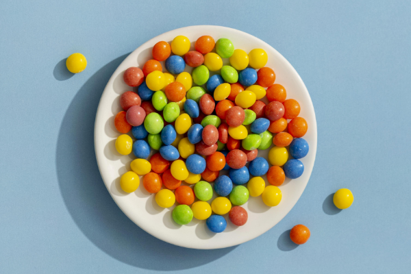 overhead-view-colorful-fruit-shape-candies-pink-background