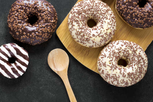 top-view-donuts-chopping-board-with-wooden-spoon